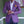 Man in paarse blazer met witte overhemd en gele pochet, kijkt naar horloge. Stijlvolle herenmode, elegante outfit, casual chic look.