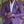 Man in paars colbert met geel pochet, witte overhemd, kijkt naar horloge. Stijlvolle herenmode, zakelijke outfit, elegante uitstraling.