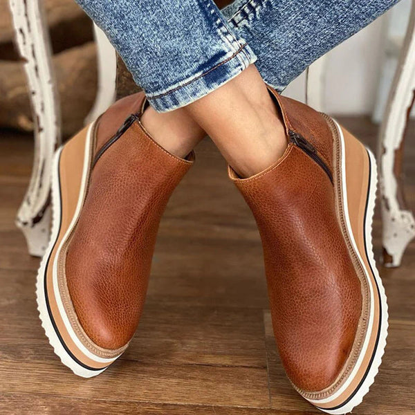 Bruine damesenkelboots met ritssluiting, dikke witte zool en casual design. Perfect voor herfstmode. Comfortabele en stijlvolle laarzen.