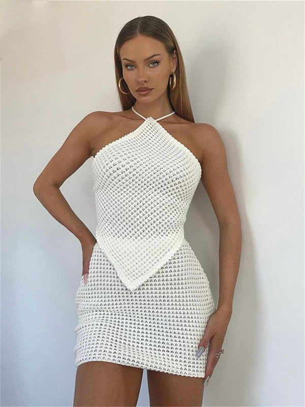 Witte gehaakte jurk, vrouw, halternek, trendy zomeroutfit, elegante stijl, modieuze kleding, casual chique, minimalistisch design, modefotografie.