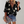 Damesblouse met bloemenprint, zwarte achtergrond, driekwart mouwen, gecombineerd met denim shorts en luipaardprint clutch. Perfect voor casual mode.