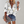 Vrouw draagt witte blouse met bloemenprint, gecombineerd met denim shorts en luipaardprint clutch. Trendy damesmode, casual zomeroutfit.