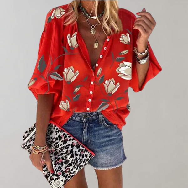 Vrouw in rode blouse met bloemenprint, denim short en luipaardprint clutch. Trendy damesmode, casual zomeroutfit, stijlvolle accessoires.