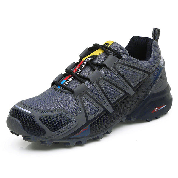 Grijze trailrunning schoen met stevige gripzool, ademend mesh en klittenbandsluiting, ideaal voor wandelen en hardlopen in ruig terrein.