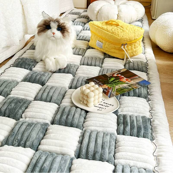 Grijze en witte geruite katoenen bankhoes met decoratieve kat, gele tas en kaars, ideaal voor stijlvolle en beschermende woonkamerinrichting.