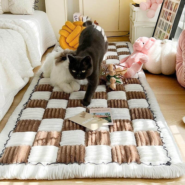 Zwart-witte kat op geruite katoenen bankhoes in woonkamer, omringd door speelgoed en decoraties. Perfect voor huisdierbescherming en interieurstijl.