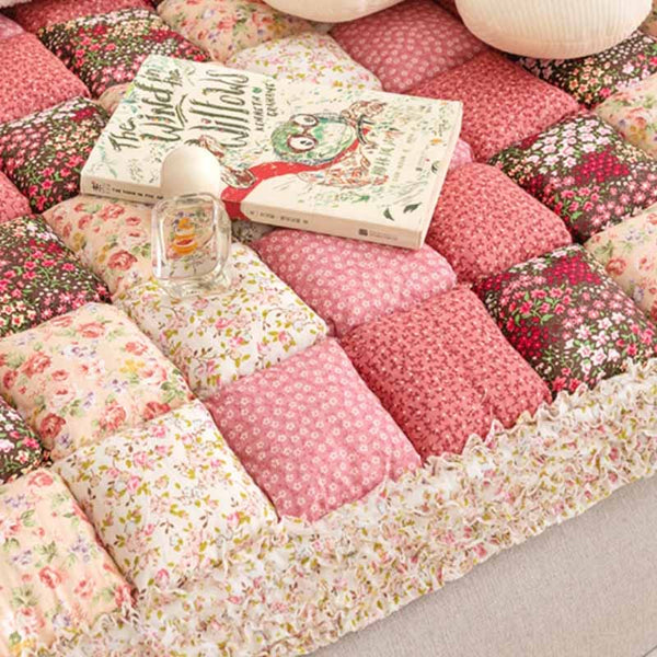 Roze en bloemen katoenen bankhoes met patchwork design, decoratieve kussens en een boek, ideaal voor woonkamerinrichting en bescherming.