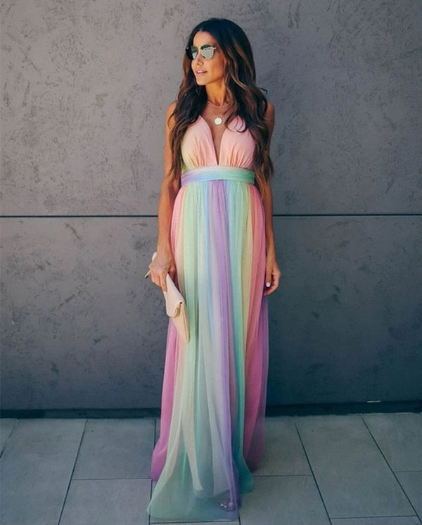 Vrouw in lange regenboogjurk met spaghettibandjes en halterhals, geschikt voor zomerfeesten en gala's. Trendy damesmode, kleurrijke avondjurk.