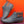 Grijze leren enkellaarsjes met bruine accenten, comfortabele zool, tegen oranje achtergrond. Stijlvolle herenschoenen, casual en modieus.