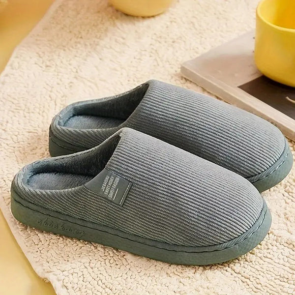 Grijze ribgebreide pantoffels op beige tapijt, comfortabele huispantoffels, warme wintermode, unisex sloffen, zachte voering, antislip zool.