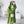 Vrouw in groene gebreide oversized cardigan, witte coltrui en beige broek, poseert met smartphone. Modieuze outfit, trendy herfstkleding.