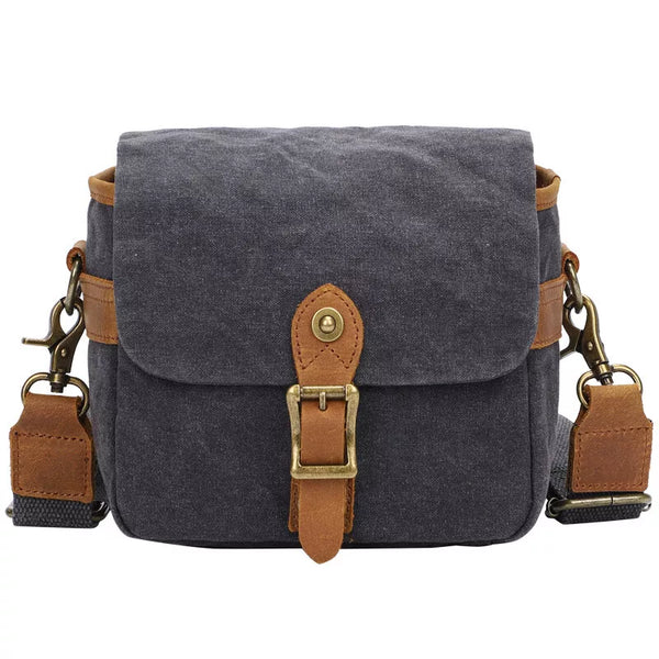 Grijze canvas schoudertas met bruine leren riemen en metalen gespen, ideaal voor dagelijks gebruik. Stijlvolle en duurzame unisex tas.