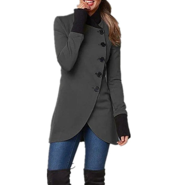 Grijze damesjas met asymmetrische knopen, lange mouwen en hoge kraag, gecombineerd met blauwe jeans. Stijlvolle wintermode voor vrouwen.