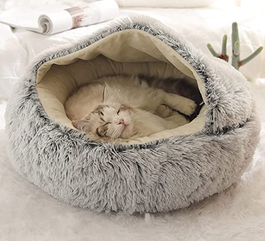Slapende kat in een grijs, pluche kattenmandje op een witte achtergrond. Comfortabel huisdierbed, perfect voor kattenrust en ontspanning.