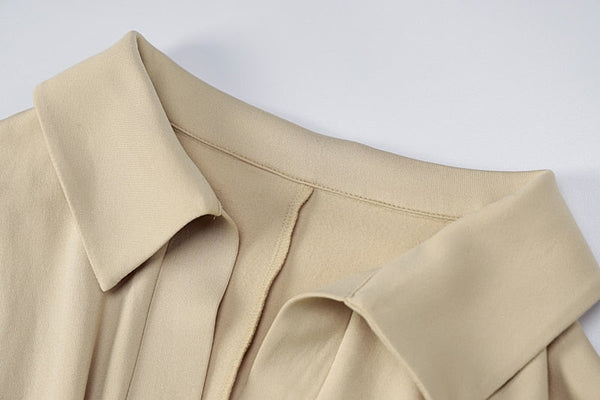 Beige blousekraag op witte achtergrond, close-up. Stijlvolle damesmode, minimalistisch ontwerp, zachte stof, trendy kledingstuk.