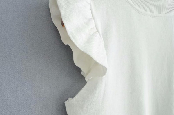 Witte damestrui met ruches, katoenen stof, minimalistisch design, close-up. Perfect voor casual en elegante outfits.