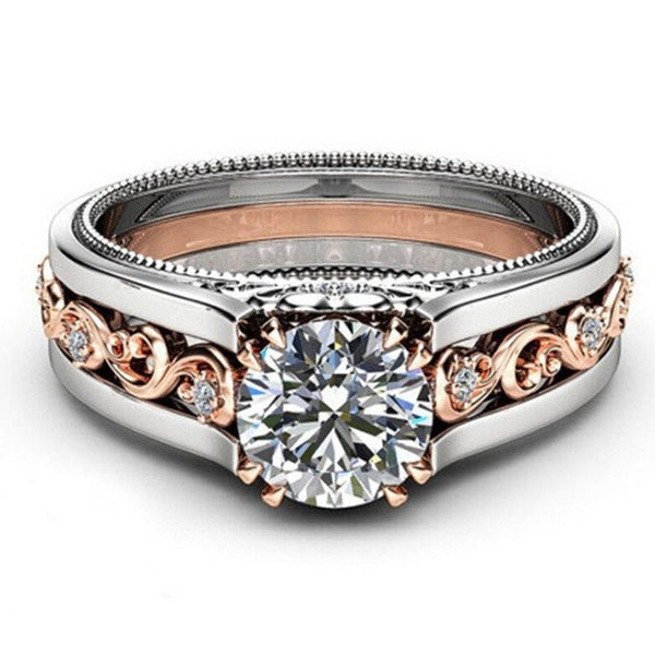 Verlovingsring met grote diamant, zilveren en roségouden band, sierlijke gravures, vintage stijl, luxe juweel, elegante uitstraling.