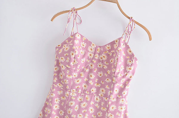 Roze zomerjurk met madeliefjesprint, spaghetti bandjes, hartvormige halslijn, op houten hanger. Perfect voor casual lente- en zomermode.