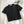 Zwarte geribbelde polo crop top op witte achtergrond, naast een bril en een kunstboek. Trendy dameskleding, casual mode, zomerstijl.
