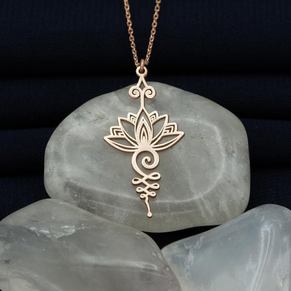 Gouden lotushanger op marmeren stenen, sieradenontwerp, spirituele symboliek, elegante ketting, bohemian stijl, handgemaakt, cadeau-idee.