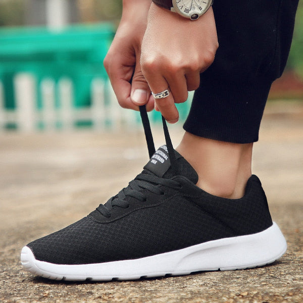 Zwarte sportschoen met witte zool, close-up van een persoon die de veters strikt. Casual en comfortabele sneakers voor dagelijks gebruik.