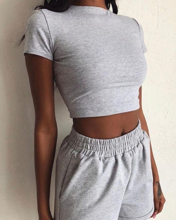 Grijze dames crop top en joggingbroek set, casual sportieve outfit, comfortabele loungewear, trendy mode voor thuis of sportschool.