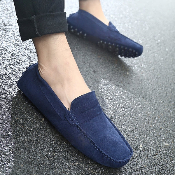 Blauwe suède loafers voor heren op nat asfalt, stijlvolle casual schoenen met antislipzool, ideaal voor dagelijks gebruik en comfort.