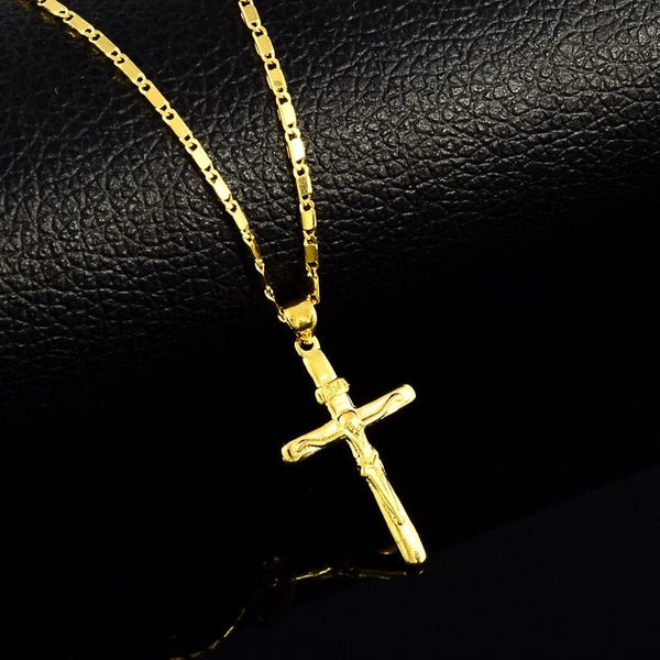 Gouden kruis ketting met gedetailleerd corpus, liggend op zwart lederen achtergrond. Perfecte religieuze sieraden voor mannen en vrouwen.