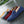 Verschillende kleuren suède loafers voor heren op natte straat, inclusief blauw, rood, zwart, grijs en geel. Stijlvolle casual schoenen.
