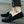 Zwarte suède loafers voor heren, gedragen op een natte straat. Comfortabele instappers met antislipzool, ideaal voor casual en formele gelegenheden.