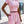 Vrouw in roze crop top en shorts, zomerse outfit, casual mode, buiten op terras, trendy dameskleding, comfortabele stijl, zonnige dag.