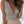 Vrouw in beige top met diepe V-hals en geplooide taille, gecombineerd met een lichte rok. Trendy zomeroutfit, casual damesmode.