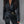Vrouw in zwarte leren blazer met gouden ketting en riem, stijlvolle mode, trendy dameskleding, elegant design, moderne outfit.
