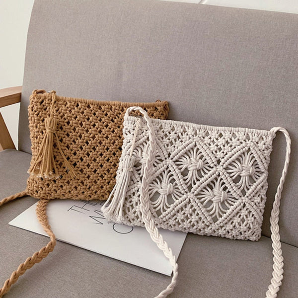 Twee handgemaakte macramé schoudertassen op een grijze bank, een beige en een witte, met gevlochten schouderbanden en decoratieve kwastjes.
