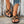 Zwarte gevlochten sandalen voor dames, gedragen met parelversierde jeans. Stijlvolle zomerschoenen, perfect voor casual en trendy outfits.