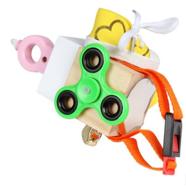 Houten fidget cube met groene spinner, oranje riem en roze bijtring. Sensorisch speelgoed voor kinderen, stressverlichting, motorische ontwikkeling.