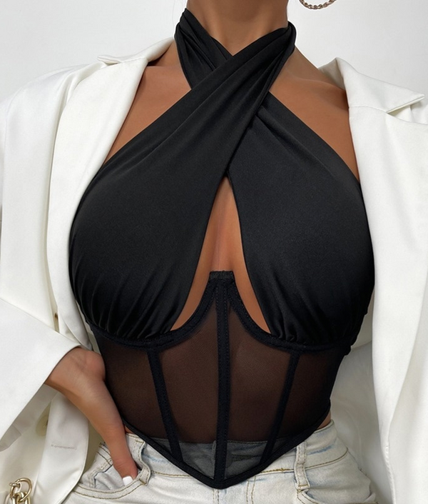 Zwarte haltertop met mesh details, gedragen onder een witte blazer. Modieuze dameskleding, ideaal voor avond- of feestoutfits.