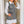 Vrouw in zwart-wit pied-de-poule jurk met witte blouse, houdt een zwarte clutch. Modieuze outfit, elegante stijl, trendy damesmode.