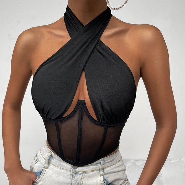 Zwarte haltertop met kruisbanden en doorschijnend mesh korset, gedragen door model. Trendy damesmode, sexy en stijlvol ontwerp.