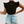 Zwarte geribbelde top met korte mouwen en hoge hals, gecombineerd met lichtblauwe denim shorts met knoopsluiting. Trendy damesmode outfit.