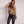 Vrouw in luipaardprint top en zwarte leren broek, modieuze outfit, trendy dameskleding, casual chique stijl, modeaccessoires, moderne look.