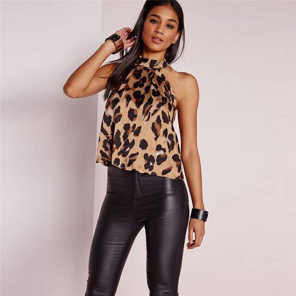 Vrouw in luipaardprint top en zwarte leren broek, modieuze outfit, trendy dameskleding, casual chique stijl, modeaccessoires, moderne look.