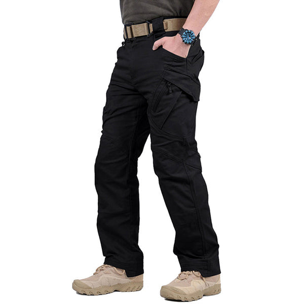 Zwarte tactische broek met meerdere zakken, gedragen door een persoon met beige laarzen en een horloge. Ideaal voor outdoor en survival activiteiten.