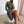 Vrouw in luipaardprint jurk zittend op witte poef, draagt zilveren sandalen. Stijlvolle mode, trendy outfit, elegante kleding.