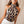 Vrouw in modieuze luipaardprint haltertop, trendy dameskleding, chique zomeroutfit, stijlvolle blouse, modeaccessoires, casual elegantie.
