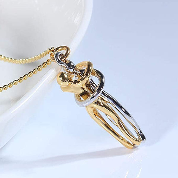 Gouden en zilveren kettinghanger in de vorm van omhelzende figuren, moderne sieraden, symbolisch ontwerp, gepresenteerd op een witte achtergrond.