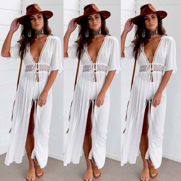 Vrouw in witte boho-jurk met diepe V-hals en kanten details, bruine hoed en sandalen. Trendy zomeroutfit, bohemian stijl, modieuze dameskleding.