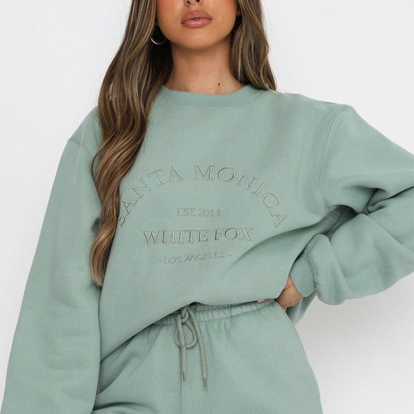 Vrouw draagt mintgroene Santa Monica sweatshirt en joggingbroek, casual mode, comfortabele dameskleding, White Fox, Los Angeles stijl.