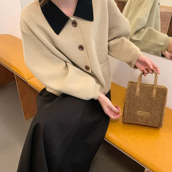 Vrouw met beige jas en zwarte kraag, houdt een bruine, wollen handtas vast. Modieuze herfstkleding, stijlvolle accessoires, trendy outfit.