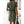 Vrouw in groene jurk met witte stippen, korte mouwen, in moderne woonkamer. Trendy zomerjurk, casual mode, dameskleding.